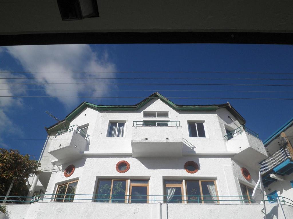 a white building with a blue sky in the background at Christys Palace Hotel in Pedoulas