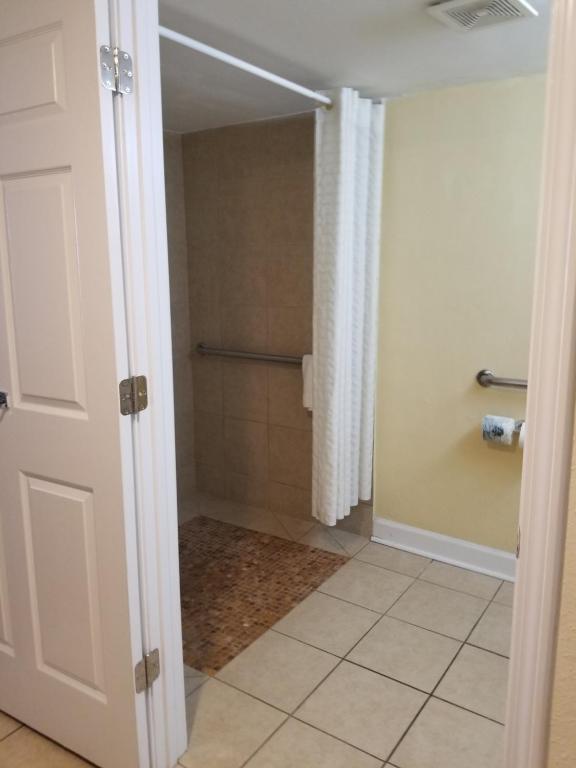 a bathroom with a walk in shower and a door at Best Western Ocean Sands Beach Resort in Myrtle Beach