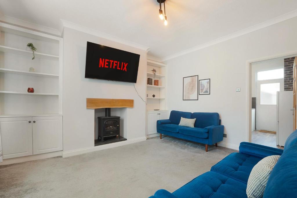 ein Wohnzimmer mit einem blauen Sofa und einem Kamin in der Unterkunft High-End home, Free Parking, 3 beds, sleeps 5 in Ferryhill