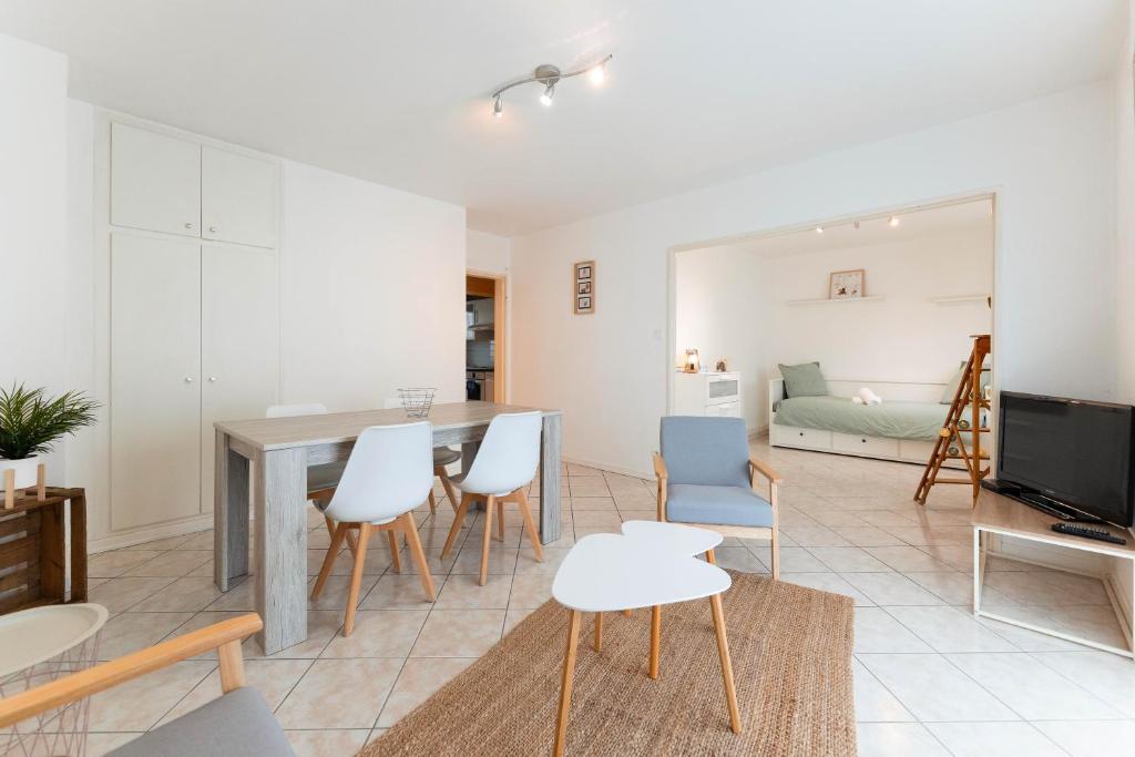 un salon avec une table et des chaises de salle à manger dans l'établissement Chez Margaux - Parking, à Colmar