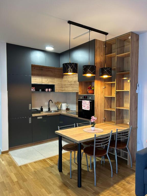 a kitchen with a table and chairs in a room at Apartman NS FREE PARKING in Novi Sad