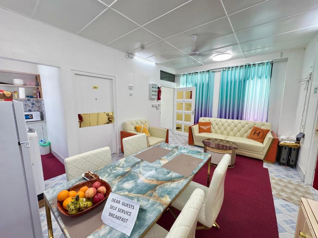 a room with a dining table and a living room at Ontrack Travel Transit Hotel in Male City