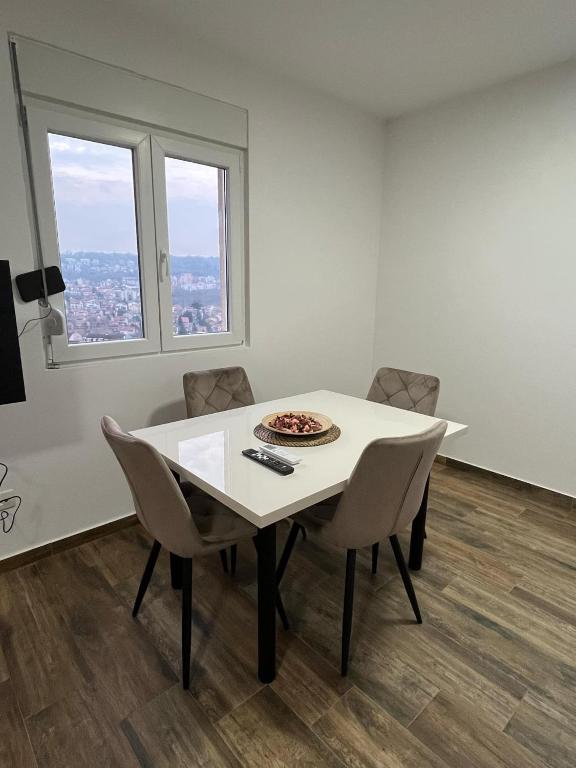a white dining room with a table and chairs at Mimura stan 2 in Belgrade