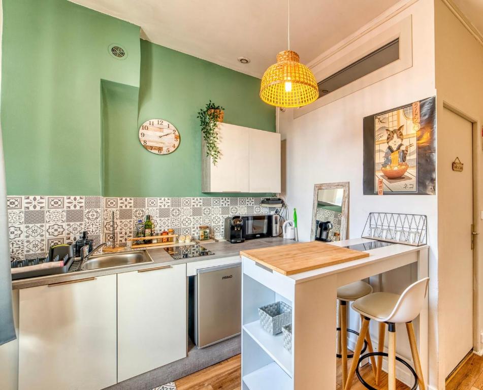 - une cuisine avec des murs verts et un comptoir dans l'établissement Le Claudius - proche tram T3 et gare Part Dieu 20 min, à Lyon