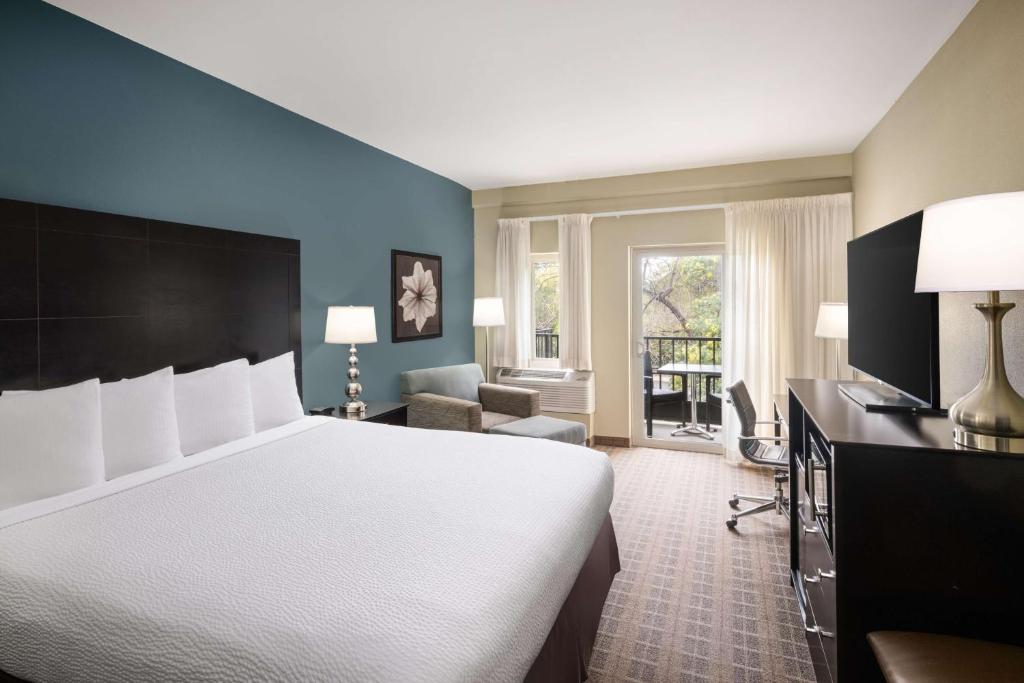a hotel room with a bed and a living room at La Cuesta Inn, BW Signature Collection in San Luis Obispo