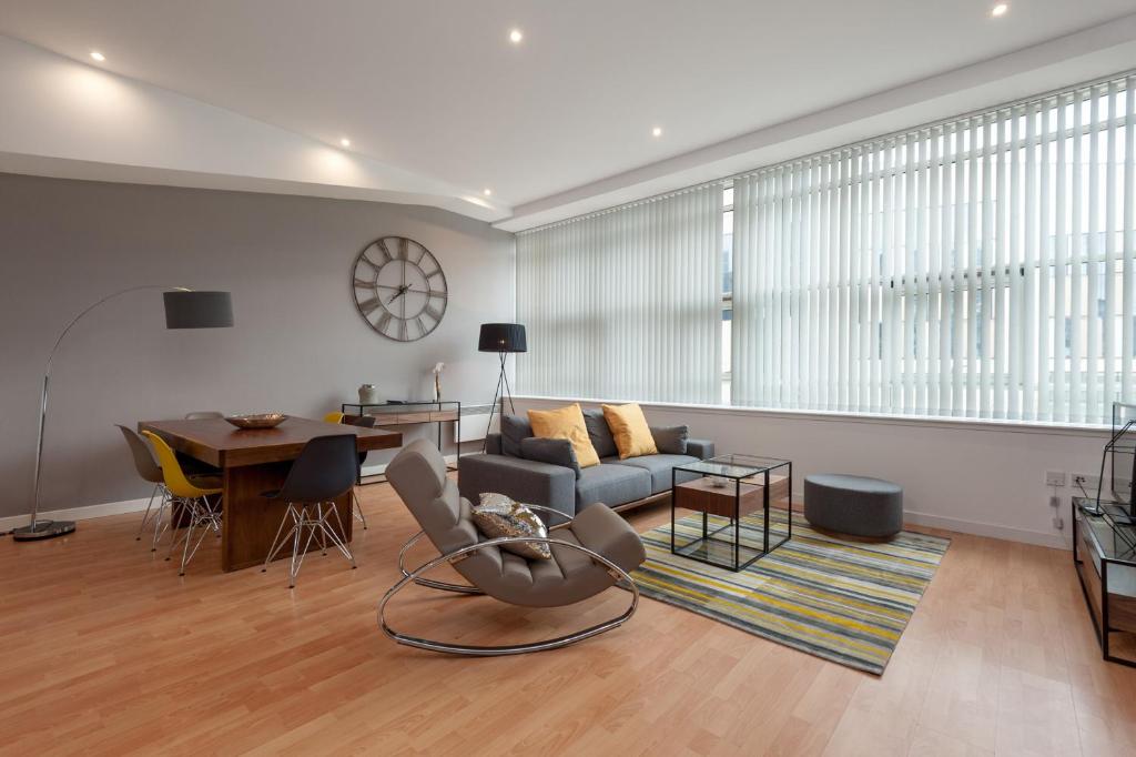 una sala de estar con un sofá y una mesa en Glasgow City Flats - Merchant City, en Glasgow