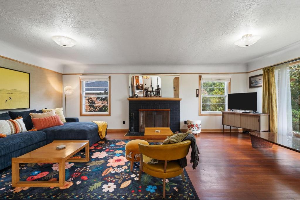 a living room with a blue couch and a fireplace at Retro Getaway In Hazel Dell in Vancouver
