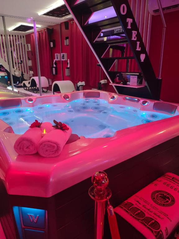 d'un bain à remous dans une chambre avec éclairage rose dans l'établissement LE QUART D'HEURE AMERICAIN, à Bailleul