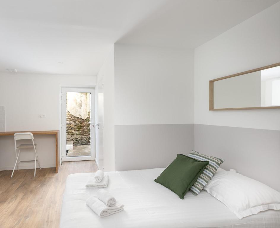 une chambre blanche avec un lit et un bureau dans l'établissement Dame Blanche, à Brest
