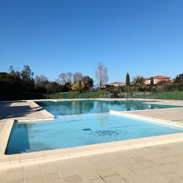 une grande piscine avec de l'eau bleue dans l'établissement Bel appartement résidence lac Aurélien, à Fréjus