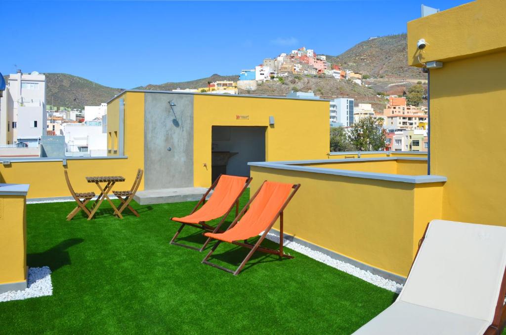 a patio with chairs and a table on a roof at Canary Lofts in Santa Cruz de Tenerife