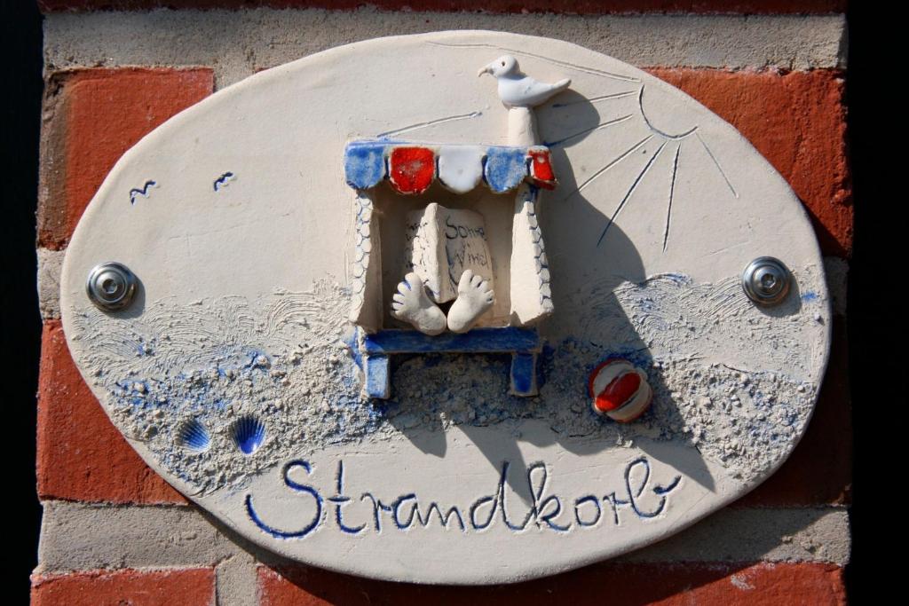 een bord aan de zijkant van een stenen muur bij Ferienwohnung "Strandkorb" in Hinrichsdorf