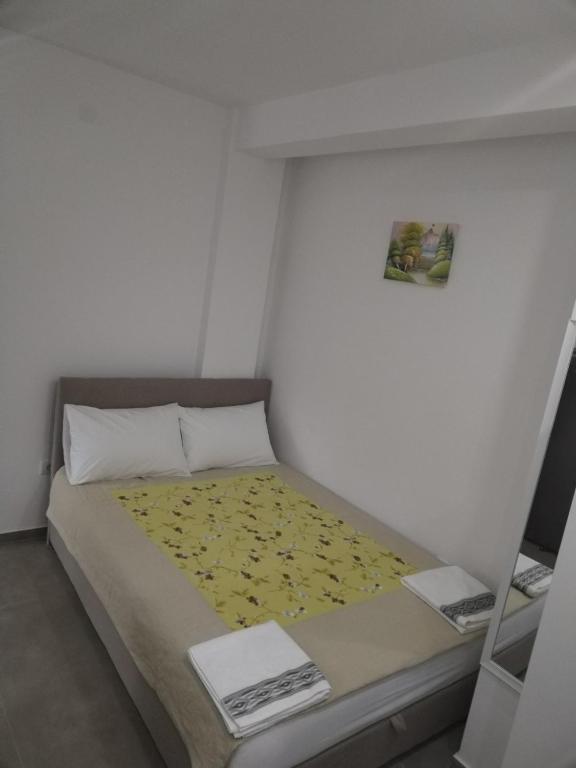 una piccola camera da letto con un letto con una coperta gialla di Divcibarski izvor a Divčibare
