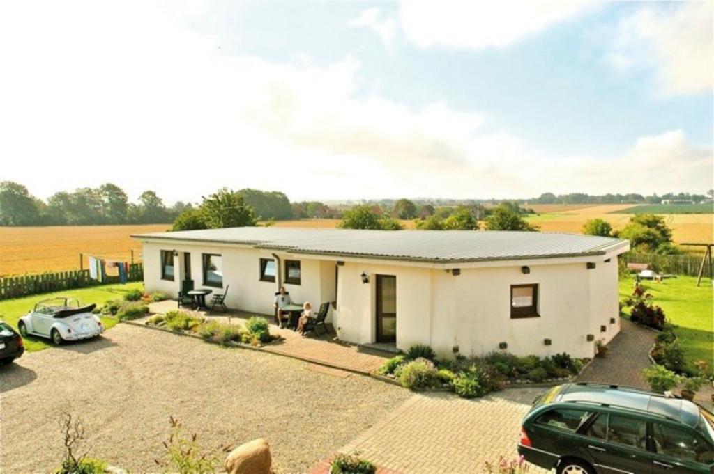 una casa bianca con auto parcheggiate in un vialetto di "Ferienhof Alte Mühle" M 1 a Bannesdorf