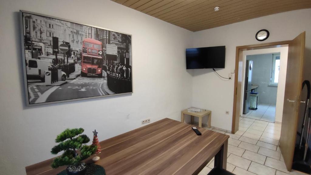 a living room with a table and a red double decker bus at Neu-Ulm City Monteurwohnung in Neu Ulm
