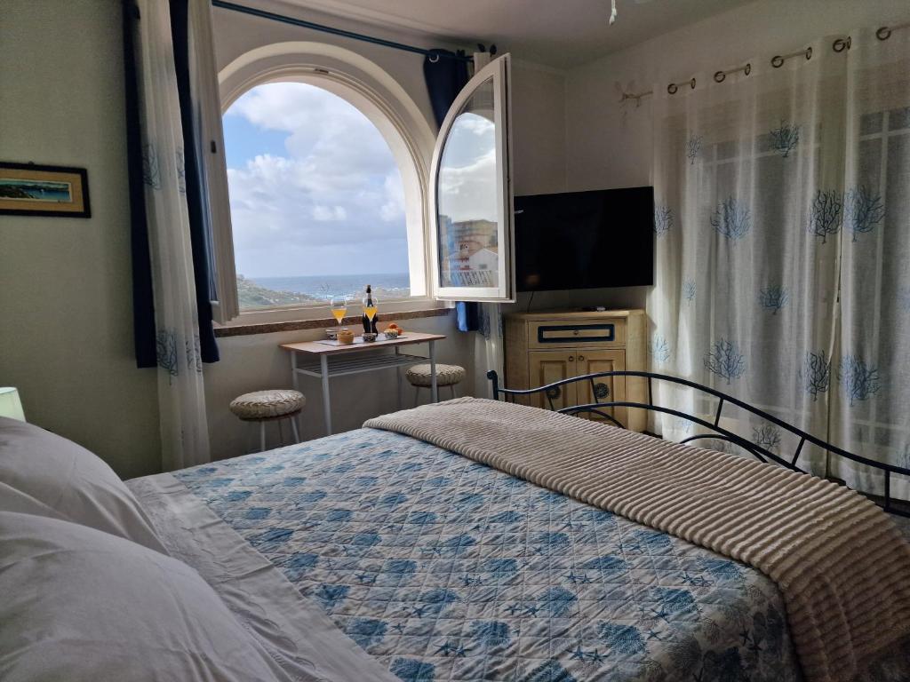 a bedroom with a bed and a large window at Giulia Suite Sea View in Santa Teresa Gallura