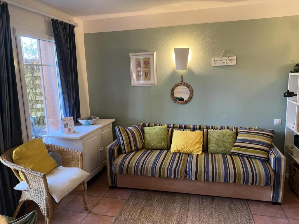 un salon avec un canapé et une chaise dans l'établissement Les Maisons de Lacanau les Pins - maeva Home - Maison 3 pièces 5 personnes - Prestige MAE-9674, à Lacanau