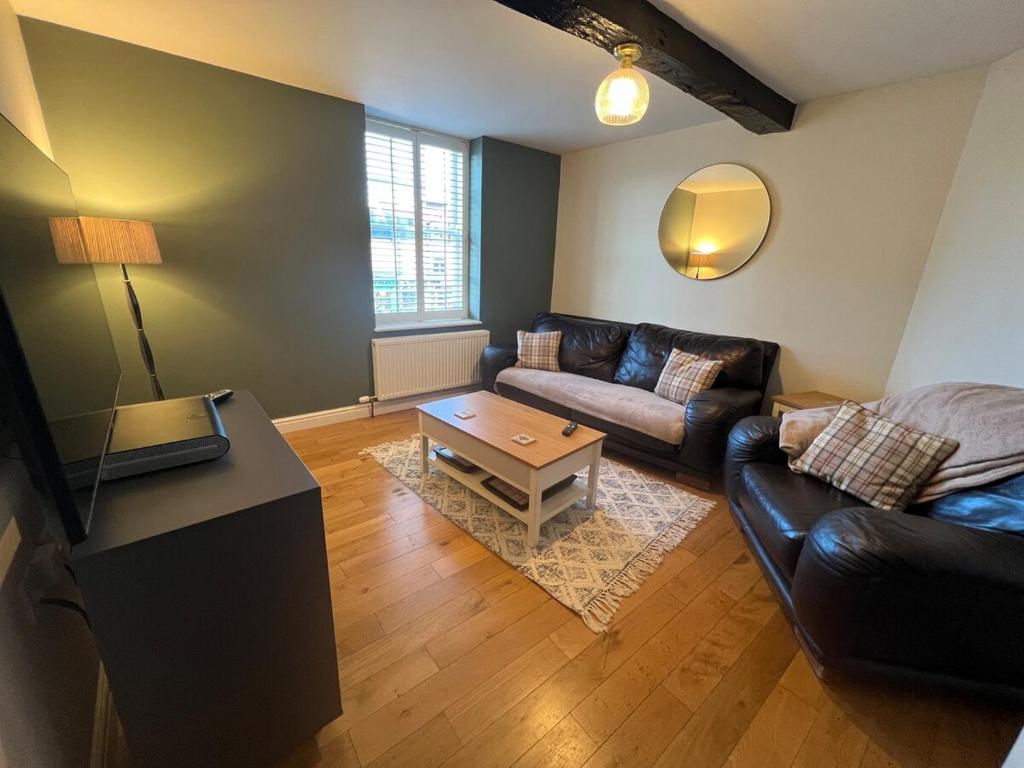a living room with a couch and a table at 2 bedroom central apartment in Hereford