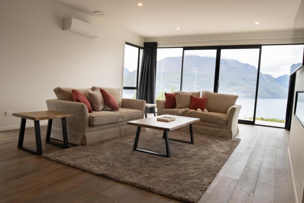 ein Wohnzimmer mit einer Couch und einem Tisch in der Unterkunft 1Queenstown - Stunning Lake and Mountain Views in Queenstown