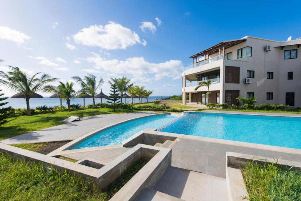 フリック・アン・フラックにあるBeachfront Heaven Apartment Flic en Flac 3の建物前スイミングプール像
