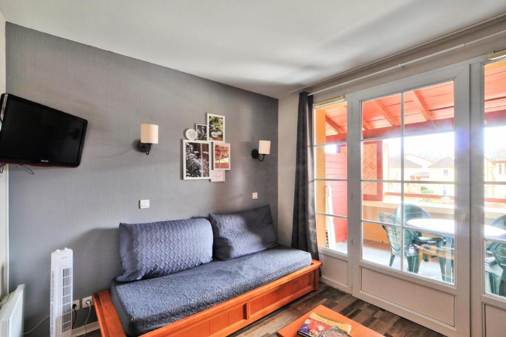 un salon avec un canapé et une télévision dans l'établissement La résidence du Lac - maeva Home - Appartement 2 pièces 5 personnes - Sélection MAE-9491, à Monflanquin