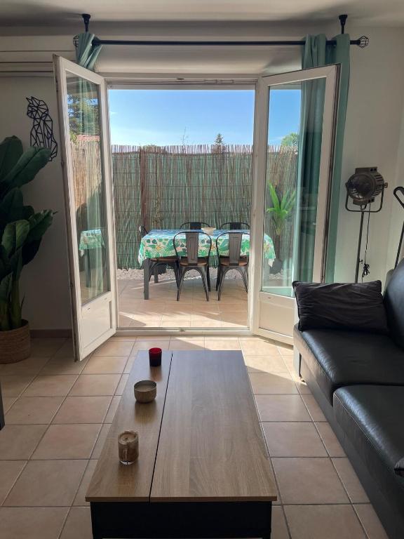 un salon avec un canapé et une table dans l'établissement Appartement rez de jardin, au Pontet