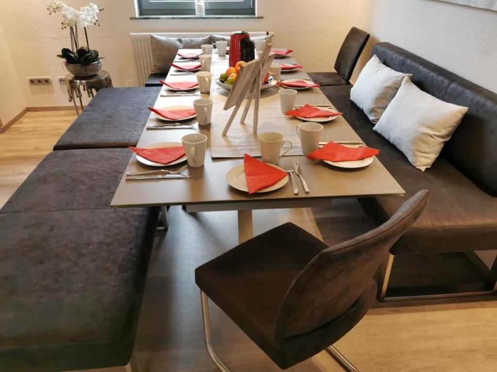ein langer Holztisch mit roten Servietten darauf in der Unterkunft Ferienhaus: Familienunterkunft bis zu 12 Personen - [#125273] in Bensheim
