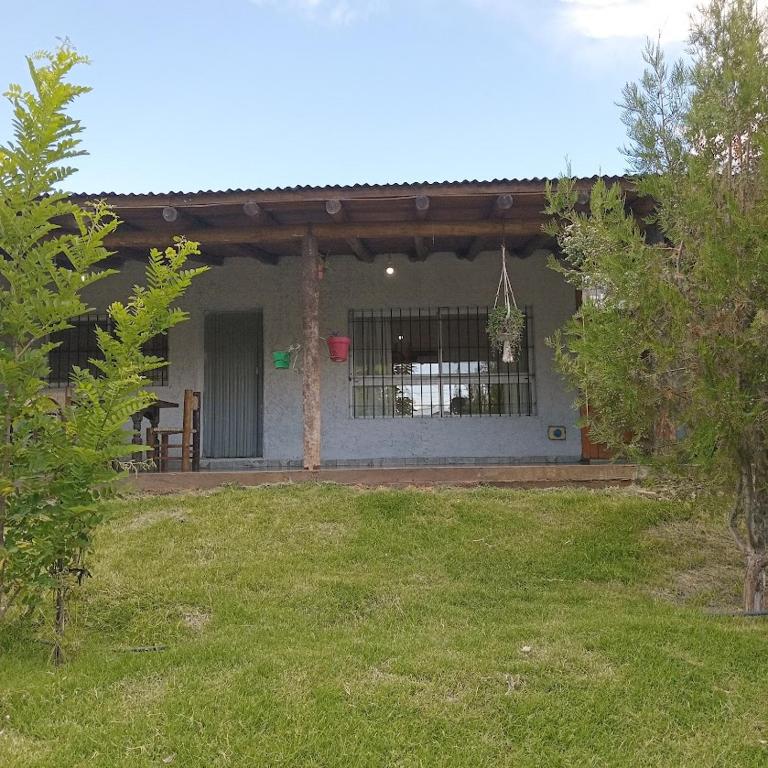 a house with a fence in the yard at Cabaña CALLE VIEJA in La Porteña