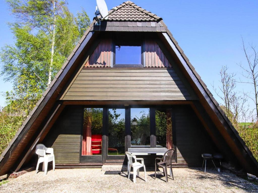 a house with a thatched roof with a table and chairs at Ferienhaus, Burhave in Burhave