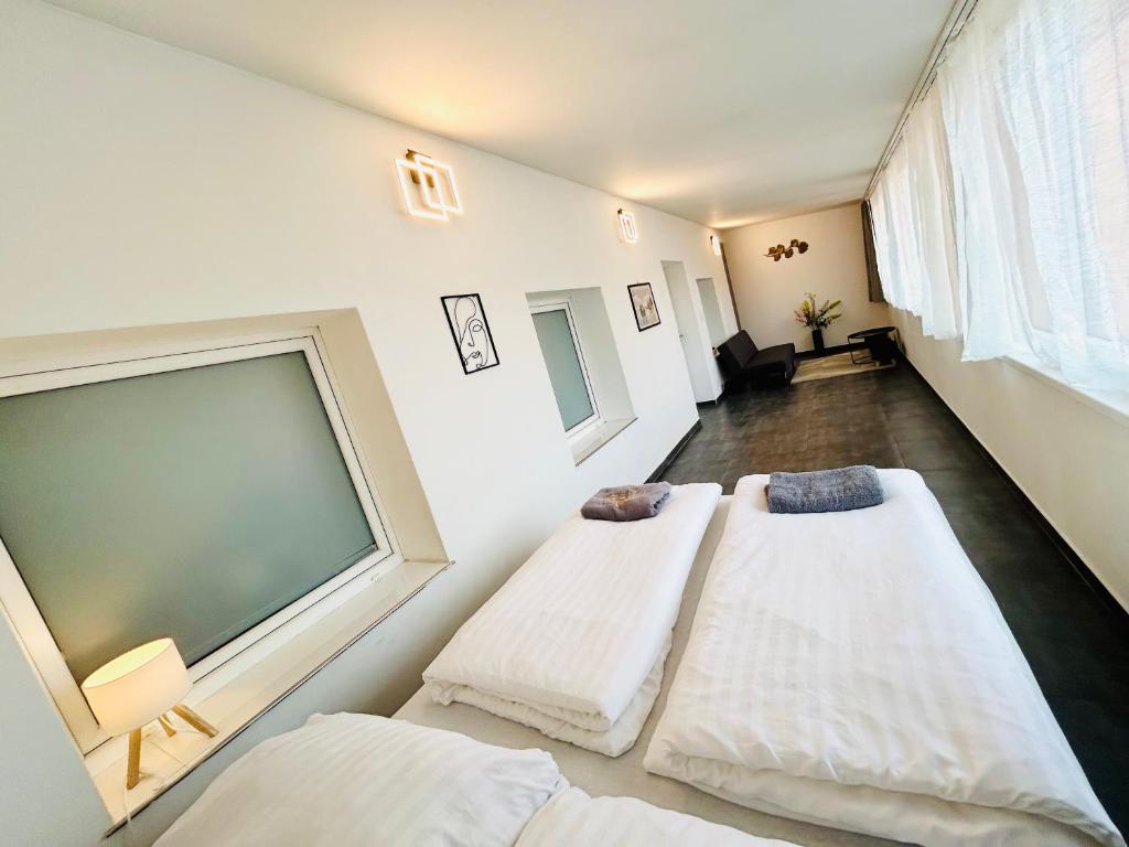 two beds in a room with a large window at Villa Apartments with Free Parking Prague 5 in Prague