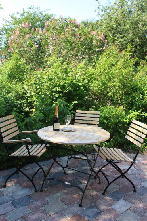 a table with a bottle of wine and two chairs at Feldlerche in Neue Tiefe Fehmarn