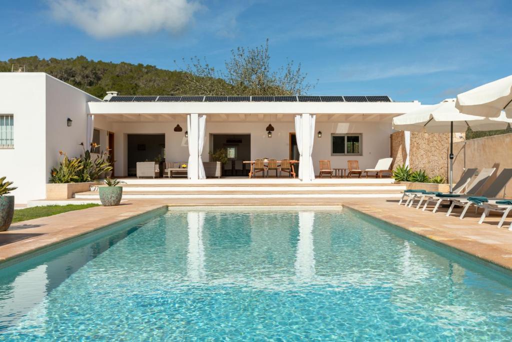 a swimming pool in front of a villa at New! Villa Can Vinyes in San Antonio