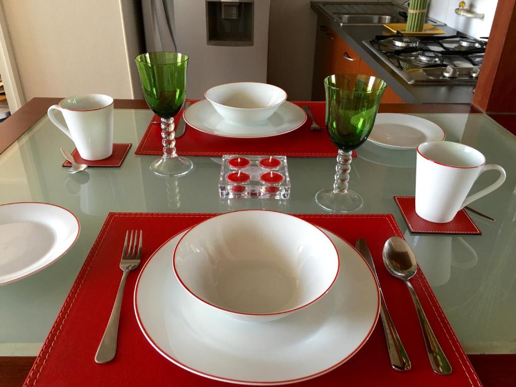 a table with a white plate and two wine glasses at Azzaí Bellas Artes in Santiago