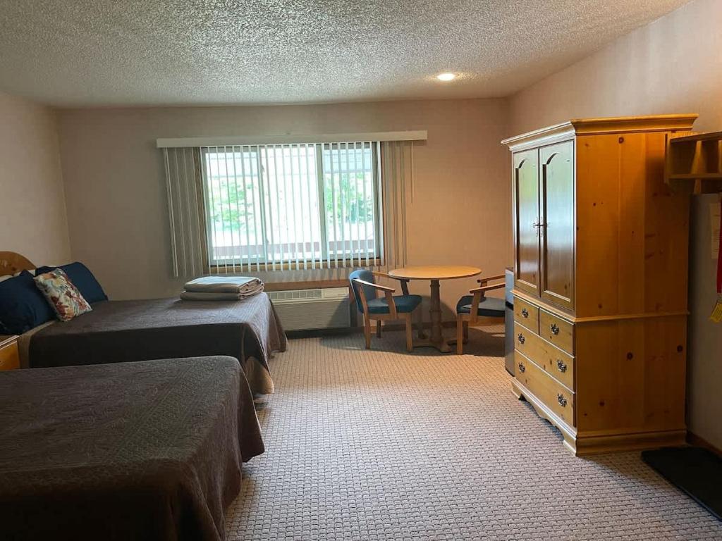 a hotel room with two beds and a table at #146 Golf, SkI, Pool Pass Walk to hill in Mancelona