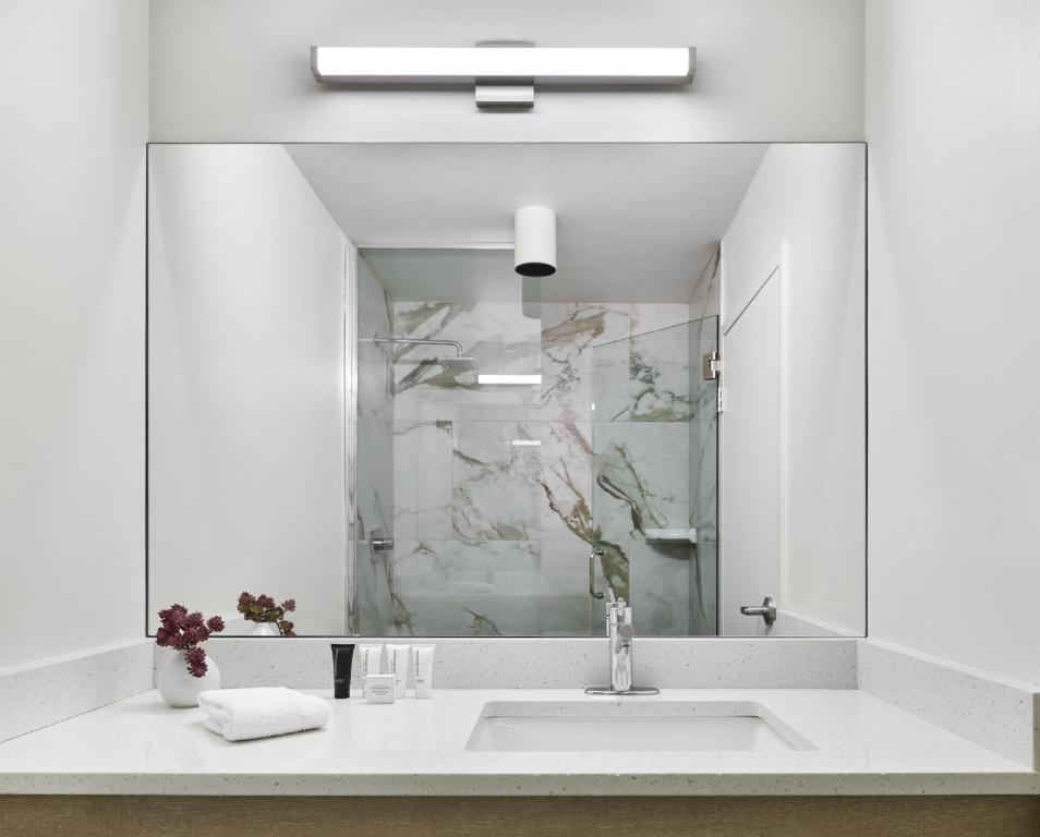 a white bathroom with a sink and a mirror at The Inn at Aspen in Aspen