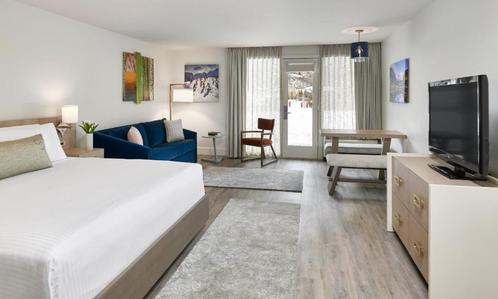 a bedroom with a bed and a living room at The Inn at Aspen in Aspen