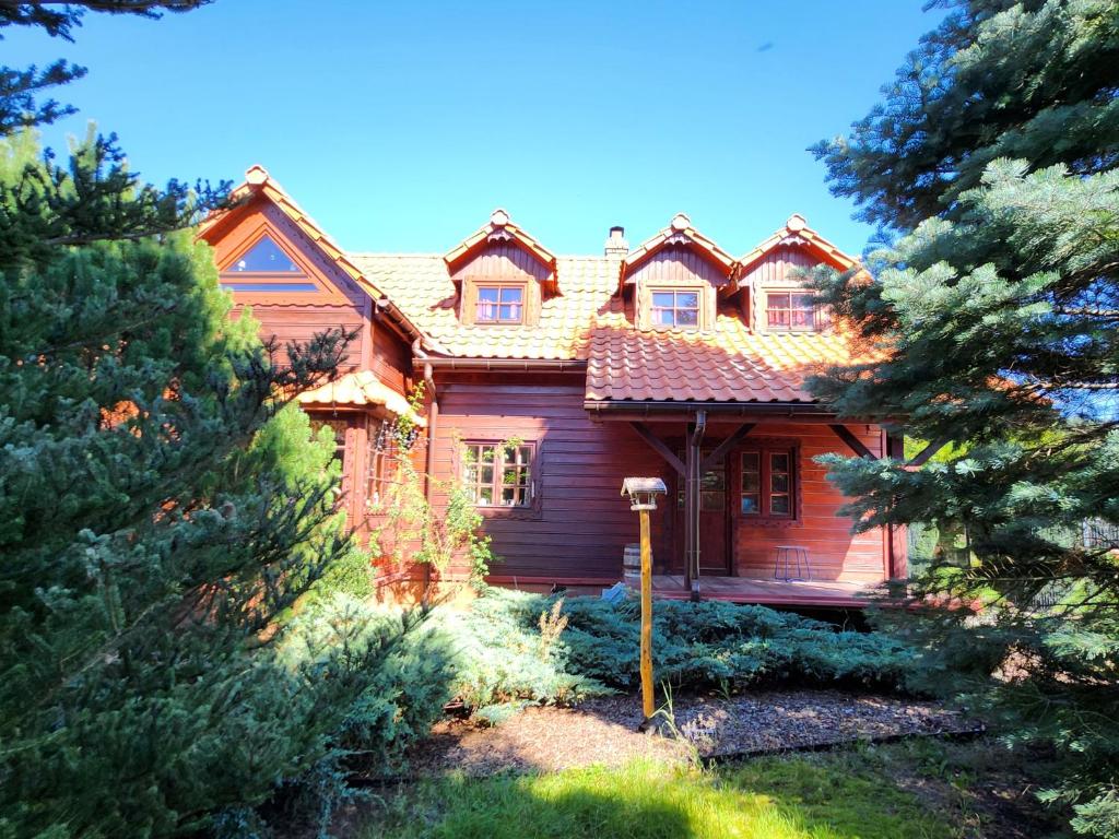 a wooden house with trees in front of it at "Koloc dom drewniany " in Ujsoły