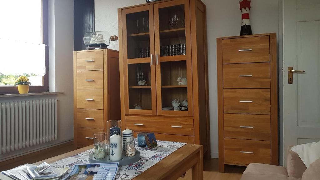 a living room with a cabinet and a table at Ferienwohnung Conny in Butjadingen