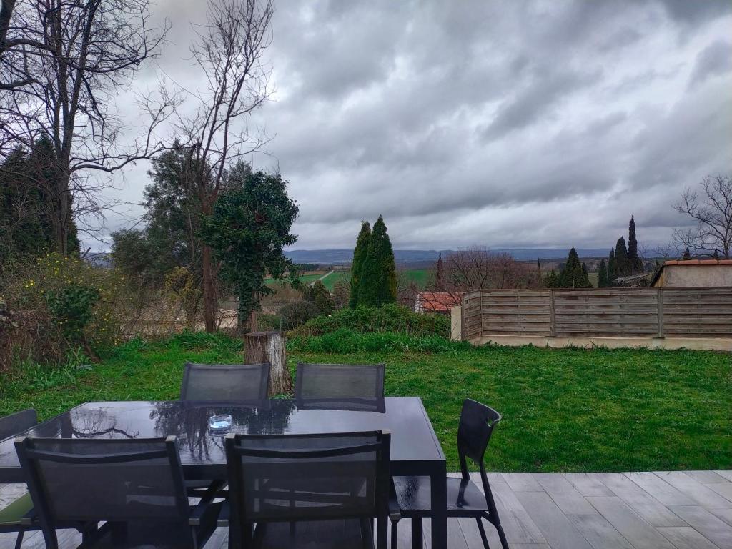 une table et des chaises assises sur une terrasse dans l'établissement Maison de village, à Lasbordes