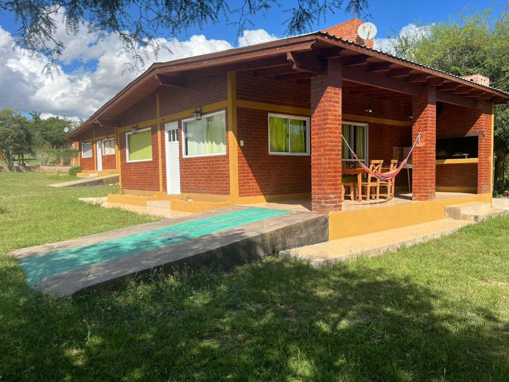 a small house in a field with a porch at Cabañas San Lorenzo in San Lorenzo