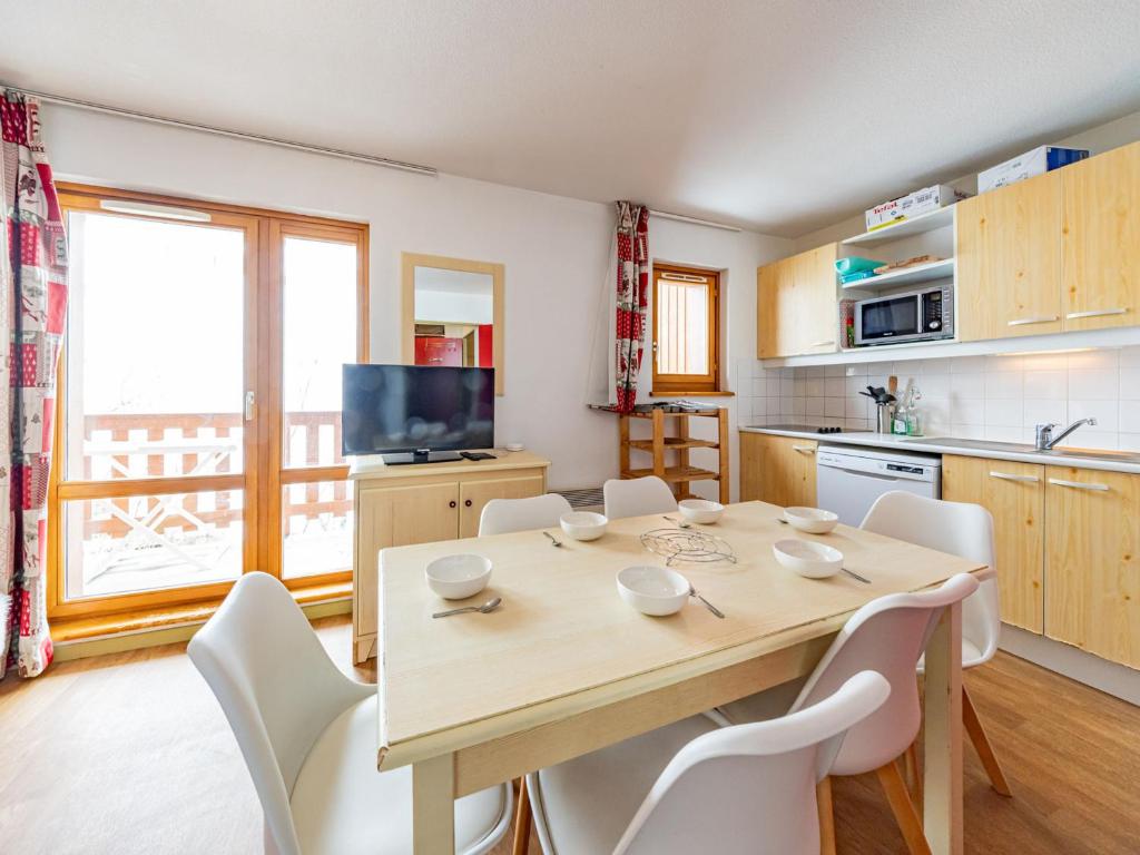 a kitchen and dining room with a wooden table and chairs at Appartement lumineux 6 pers aux pieds des pistes, Saint-François-Longchamp - FR-1-807-30 in Saint-François-Longchamp