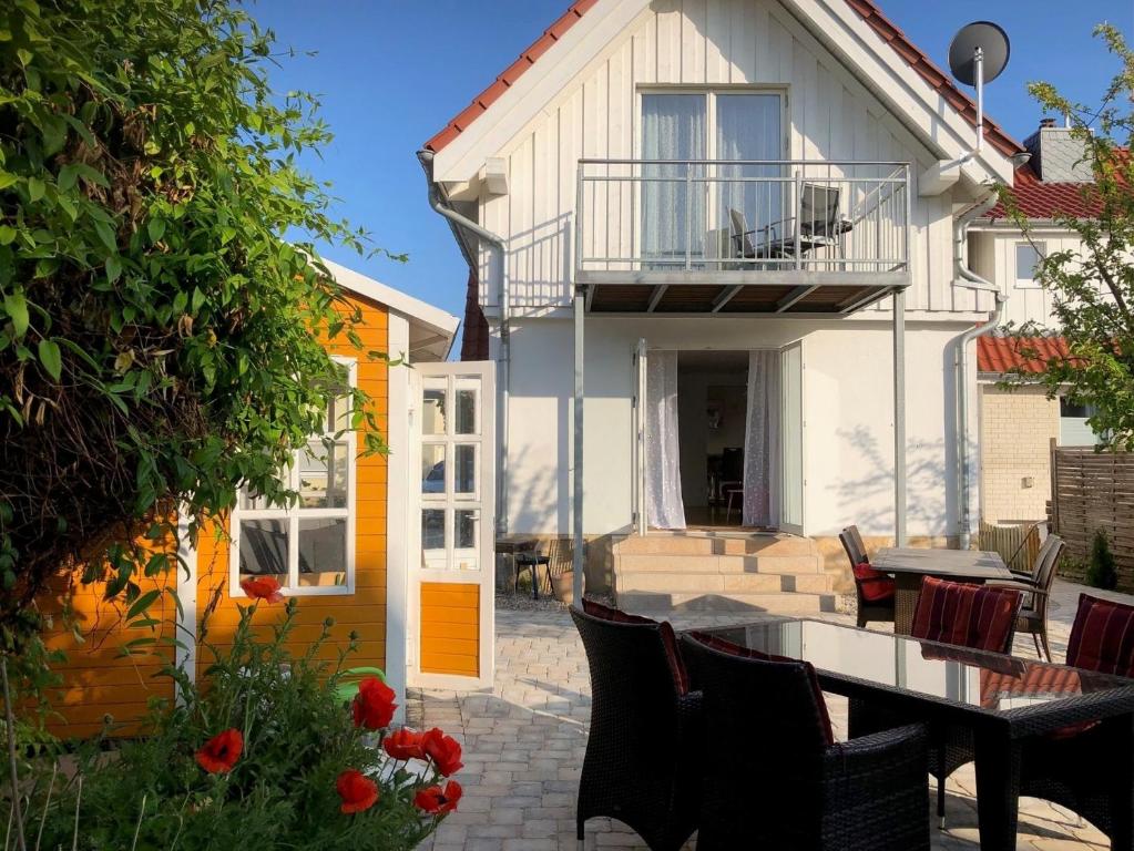 Un patio con una mesa y sillas frente a una casa. en Ferienhaus Sandmohn, en Kellenhusen
