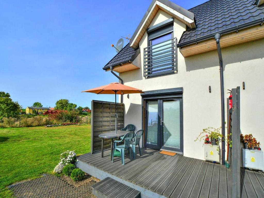 a deck with a table and chairs and an umbrella at Holiday cottages, close to the beach, Ustronie in Ustronie Morskie