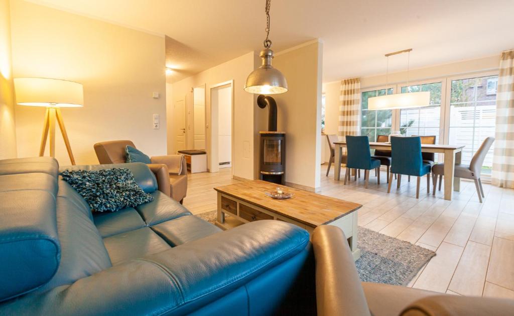 a living room with a blue couch and a table at Seewolf in Zingst