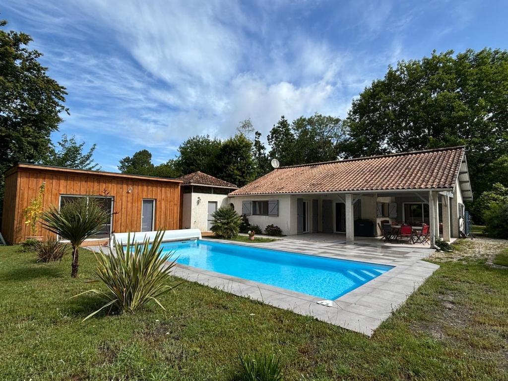 une maison avec une piscine dans une cour dans l'établissement Villa entre terre et océan, à Grayan-et-lʼHôpital