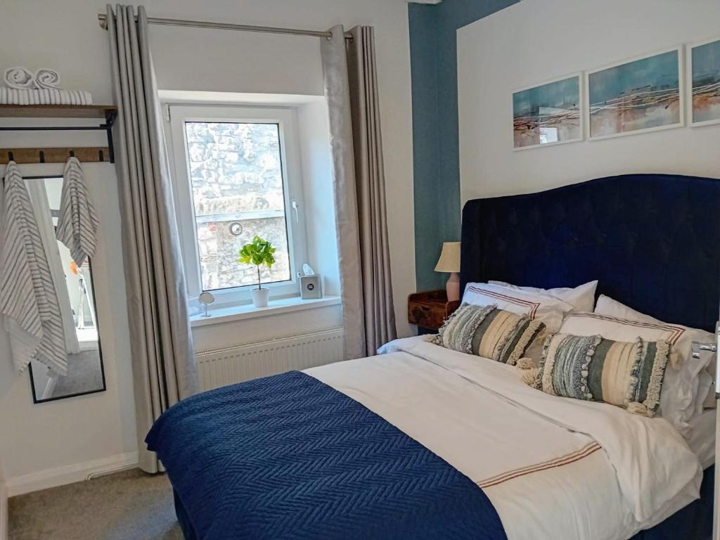 a bedroom with a large bed with a window at Happy Days Town House in Bridgend