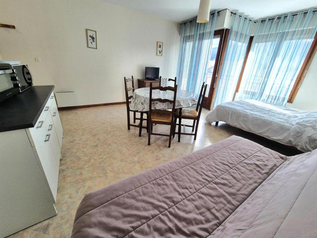 Cette chambre comprend une cuisine et une salle à manger avec une table. dans l'établissement Résidence Le Chateau Durieux 3 - Studio spacieux et proche tous commerces ! MAE-7464, à Aix-les-Bains