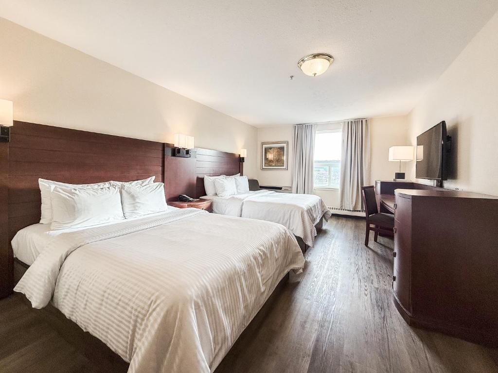 a hotel room with two beds and a television at West Edmonton Mall Inn in Edmonton