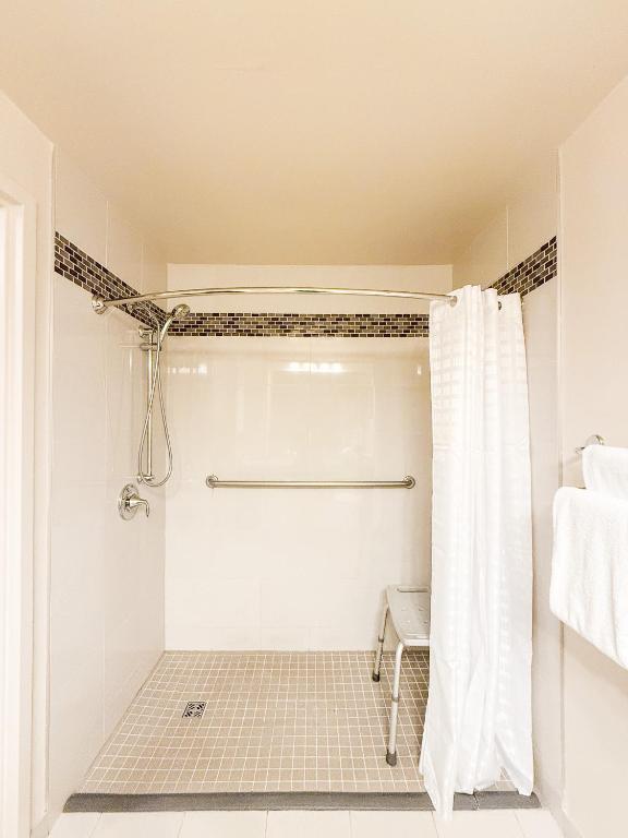 a white bathroom with a shower with a shower curtain at West Edmonton Mall Inn in Edmonton
