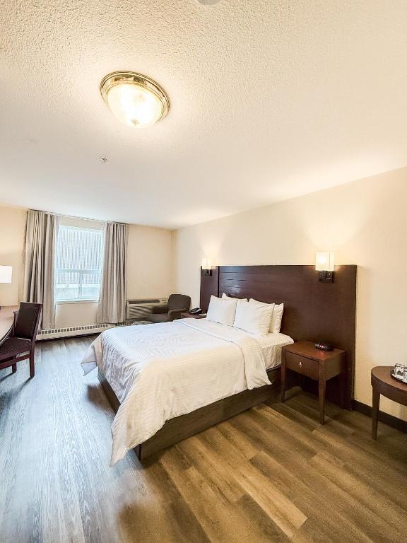 a hotel room with a large bed and a window at West Edmonton Mall Inn in Edmonton
